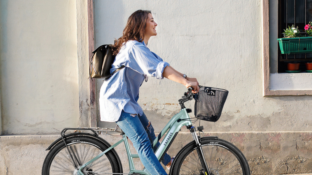 Woman riding a Fafrees e-bike next to a house 