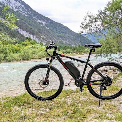 Eleglide M2 29" Electric Mountain Bike, 15.5MPH on its side stand next to a river in a wild country side setting 