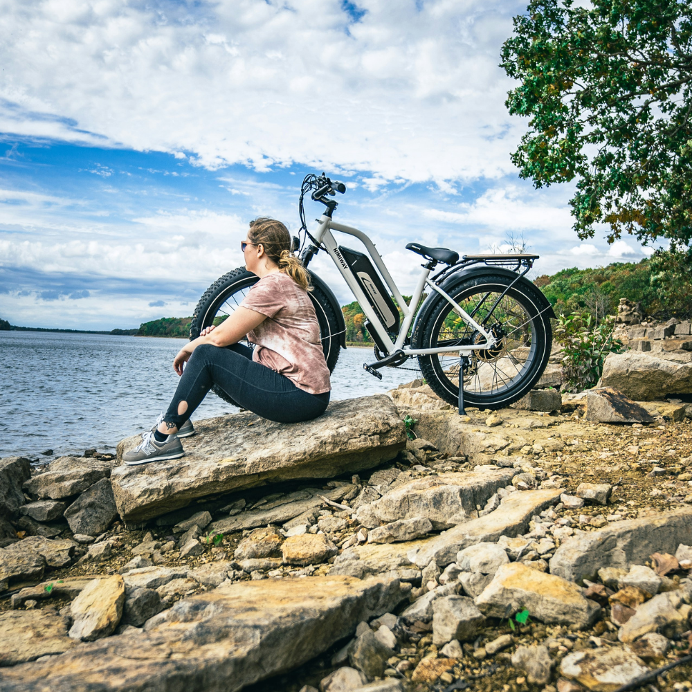 Himiway Cruiser ST resting on rocks with a woman.