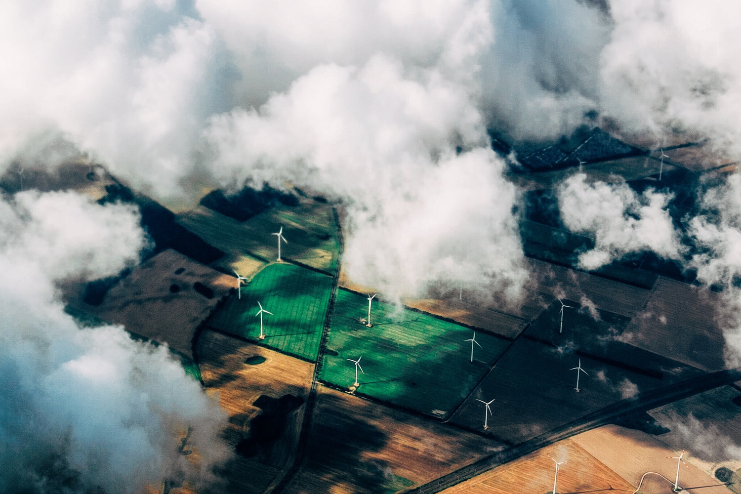 thomas-richter-B09tL5bSQJk-unsplash Wind Turbines on fields with clouds - About us page power drive bikes 